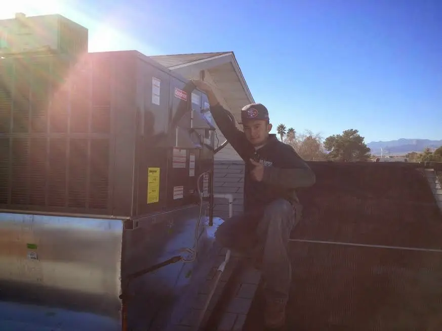 HVAC technician performing AC Tune-Up on a rooftop unit in Toronto